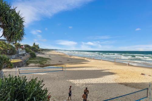 people playing soccer on a beach with the ocean at Tides & Tails Abode - Coolum Beach Pet Friendly Home in Coolum Beach