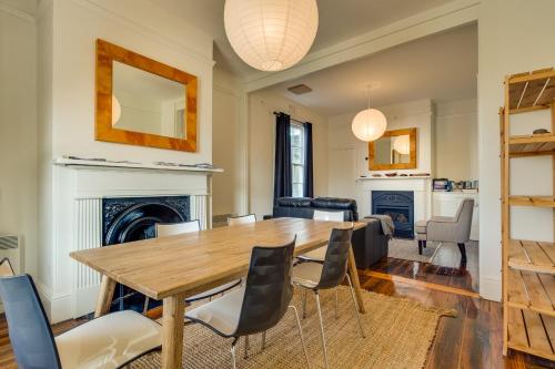 a dining room with a table and chairs and a fireplace at Brampton Cottage in Hobart