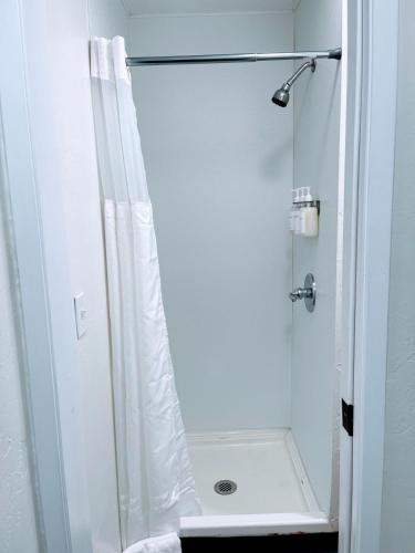 a shower with a white shower curtain in a bathroom at Redwood Nook - 8 min walk to redwood state park in Felton
