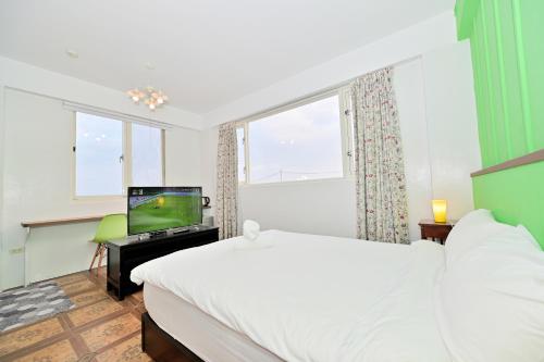 a bedroom with a bed and a flat screen tv at 波斯卡朵親子城堡渡假民宿 in Magong