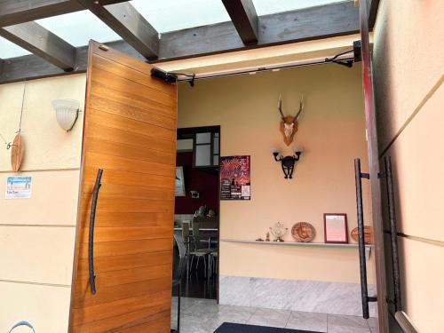 a room with a door with a deer head on the wall at Calm Lanai Harbor in Nichinan