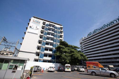 a parking lot with cars parked in front of a building at D haus Ngamwongwan Residence in Nonthaburi