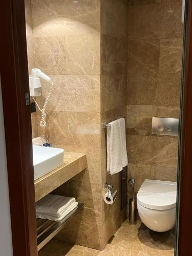 a bathroom with a white toilet and a sink at The Way Hotel in Istanbul