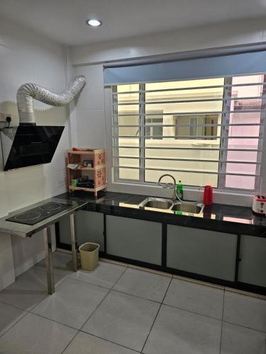a kitchen with a counter and a sink and a window at Cahaya Villa 2452 in Miri