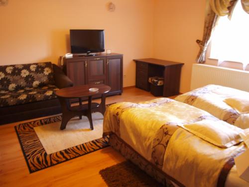 a living room with two beds and a table and a couch at Apartamenty Willa Park in Żagań