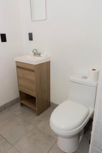 a bathroom with a white toilet and a sink at Cabaña frente al mar in Coronel Esteban Cantú