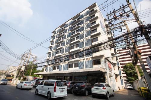 a tall building with cars parked in front of it at D haus Ngamwongwan Residence in Nonthaburi