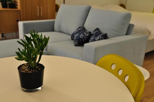 a white table with a potted plant on it next to a couch at Cadix 35 in Antwerp