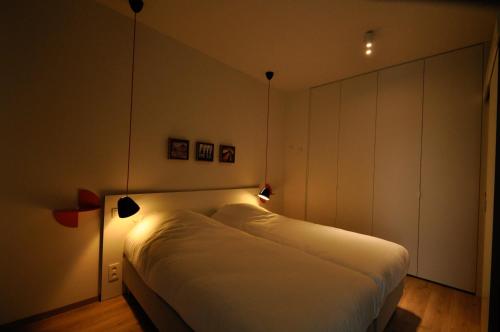 a bedroom with a white bed with lights on it at Cadix 35 in Antwerp