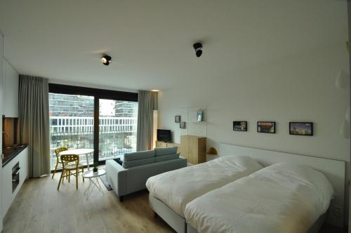 a bedroom with a bed and a chair and a window at Cadix 35 in Antwerp