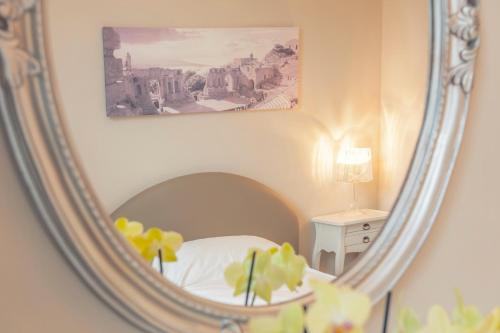 a mirror reflecting a bedroom with a bed and a painting at La Cucina - Hotel & Restaurant in Peggau