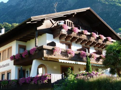 um edifício com flores nas varandas em Pension Hauenstein em Lagundo