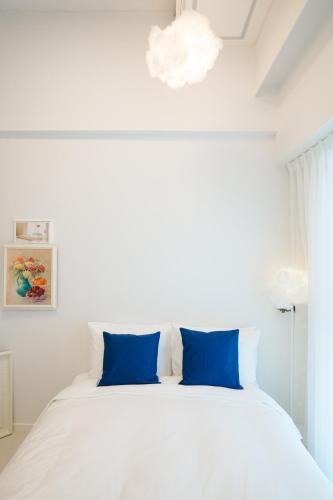 a bedroom with a large white bed with blue pillows at Blue Ocean Hotel 4 in Incheon
