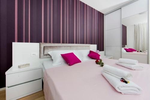 a bedroom with a large white bed with pink pillows at Luxury Apartment "Ema", sea view in Split