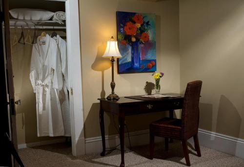 a desk with a lamp and a chair in a room at Canal Street Inn in New Orleans