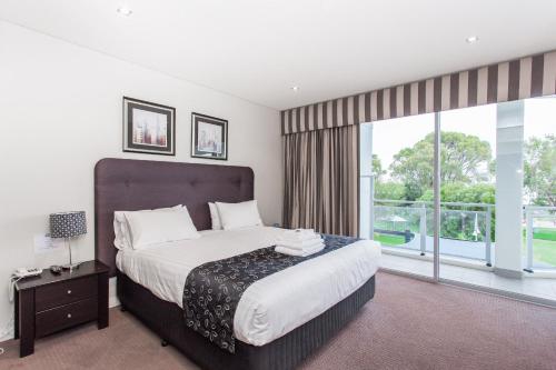 a bedroom with a large bed and a large window at Spinnakers by Rockingham Apartments in Rockingham