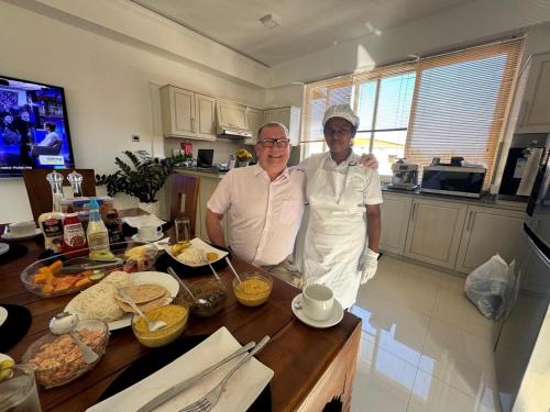 two men standing next to a table in a kitchen at Anna Asia Villa in Kandy