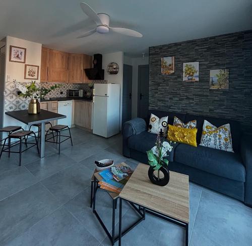 un salon avec un canapé bleu et une cuisine dans l'établissement Appartement port Frejus, à Fréjus