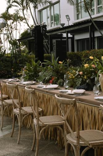 a long wooden table with chairs and flowers on it at Marco Polo Xiamen in Xiamen