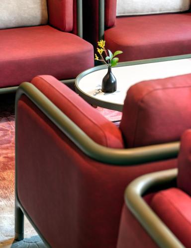 a row of red chairs with a table in a room at JOYA Shanghai Gubei in Shanghai