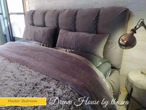 a bed with a purple blanket and a lamp at DREAM house by the sea in Epanomi