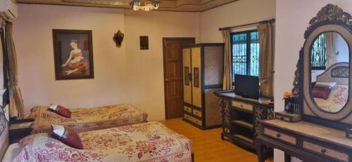Un dormitorio con dos camas y un espejo. en Phufatara Resort, en Ban Huai Chomphu