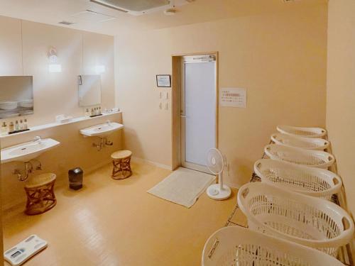 a bathroom with a row of white chairs and sinks at Ogal Inn in Yahaba