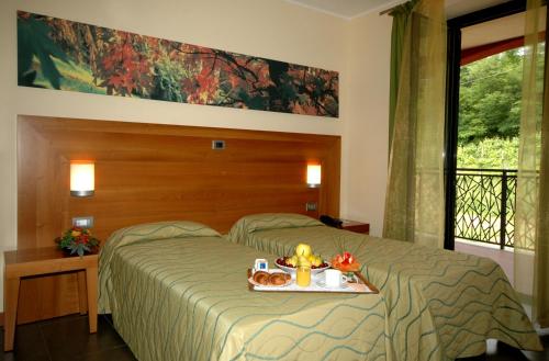 a bedroom with a bed with a tray of food on it at Hotel Langhe & Monferrato in Costigliole dʼAsti