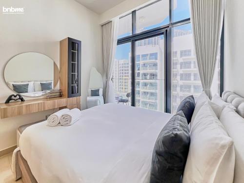 a bedroom with a large bed with a large window at bnbmehomes - Azizi Riviera 45 in Dubai