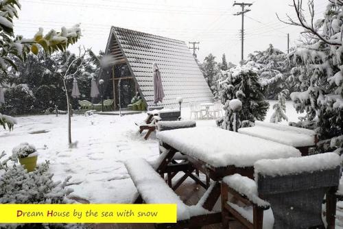 a yard covered in snow with a table and benches at DREAM house by the sea in Epanomi