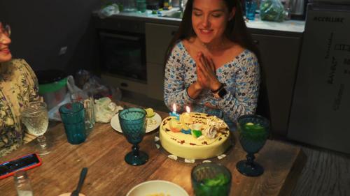 a woman standing in front of a birthday cake with candles at DREAM house by the sea in Epanomi