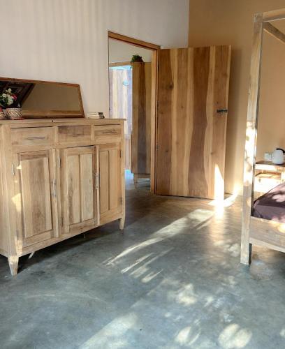 a bedroom with a wooden dresser and wooden doors at Villa Arugam Bay in Arugam Bay