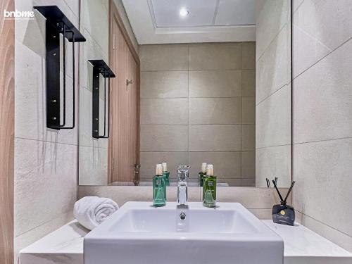 a bathroom with a white sink and a mirror at bnbmehomes - Azizi Riviera 45 in Dubai