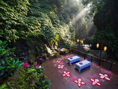 two beds on a wooden deck in a forest at Nandini Jungle by Hanging Gardens in Payangan
