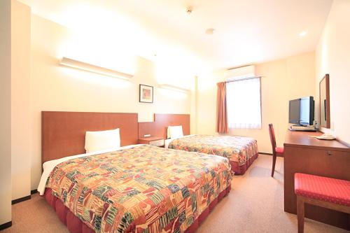 東広島市にあるベッセルホテル東広島のベッド2台とテレビが備わるホテルルームです。