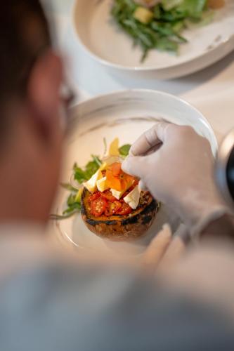 a person eating a piece of food on a plate at Maia Resort Quy Nhon in Quy Nhon