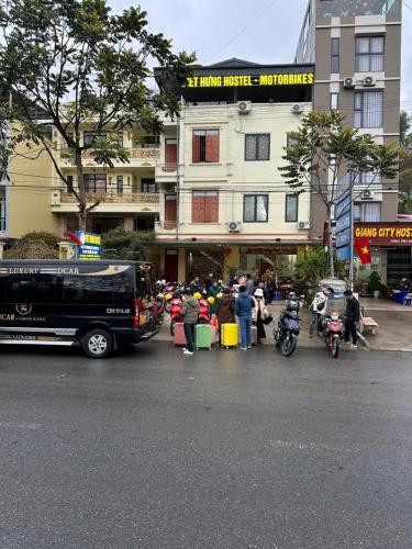 a group of people standing in front of a building at VIỆT HƯNG HÀ GIANG Hostel motorbikes for rental in Ha Giang