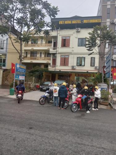 a group of people on motorcycles in front of a building at VIỆT HƯNG HÀ GIANG Hostel motorbikes for rental in Ha Giang