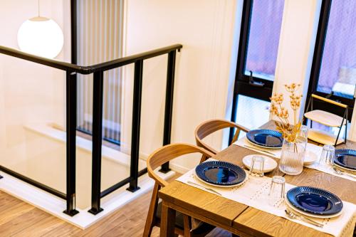 a dining room with a table with blue plates on it at J S暁宅-睦月 mutsuki in Osaka