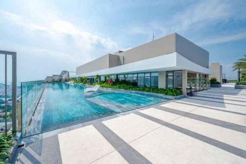 a house with a swimming pool in front of a building at Erica's House - Oceanview The Sóng Apartment Vũng Tàu Nghỉ Dưỡng Biển Cao Cấp 5 Sao - The Song Vung Tau Condotel 5 Star Beach View Apartment in Vung Tau