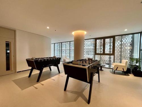 a living room with two game tables in it at Erica's House - Oceanview The Sóng Apartment Vũng Tàu Nghỉ Dưỡng Biển Cao Cấp 5 Sao - The Song Vung Tau Condotel 5 Star Beach View Apartment in Vung Tau
