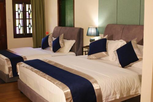 two beds in a hotel room with two at Penang Story LINN House in George Town