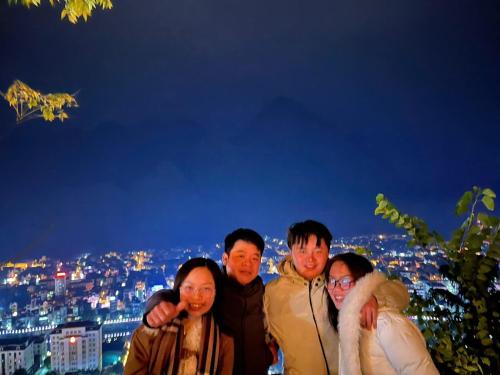 a group of people posing for a picture at night at VIỆT HƯNG HÀ GIANG Hostel motorbikes for rental in Ha Giang