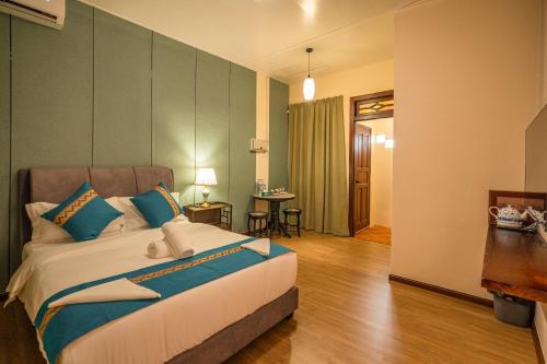 a bedroom with a large bed with blue pillows at Penang Story LINN House in George Town