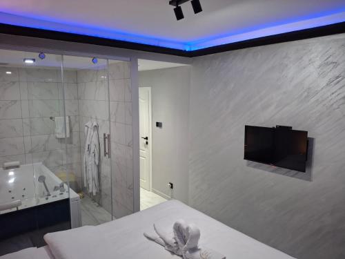 a bathroom with a bed and a tub and a tv on a wall at Spa intimo Višegrad in Višegrad