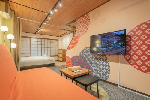 a room with a bed and a tv on the wall at 黑门市场 in Osaka