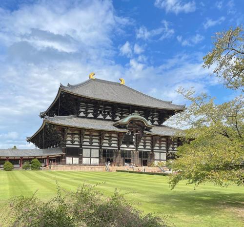 un grande edificio con tetto in un campo di Nara Guesthouse 3F a Nara