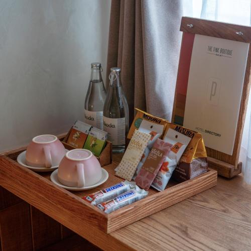 a table with a tray with tea cups and magazines at The Pink Boutique Hotel in Da Lat