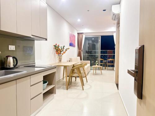 a kitchen and living room with a table and chairs at Erica's House - Oceanview The Sóng Apartment Vũng Tàu Nghỉ Dưỡng Biển Cao Cấp 5 Sao - The Song Vung Tau Condotel 5 Star Beach View Apartment in Vung Tau