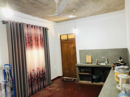 a kitchen with a sink and a shower curtain at Wakishta Villa - Weligama in Weligama